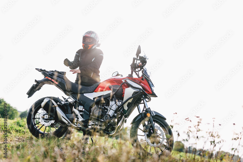 Woman preparing to drive a motorbike. Wearing gloves Woman preparing to drive a motorbike. Wearing gloves