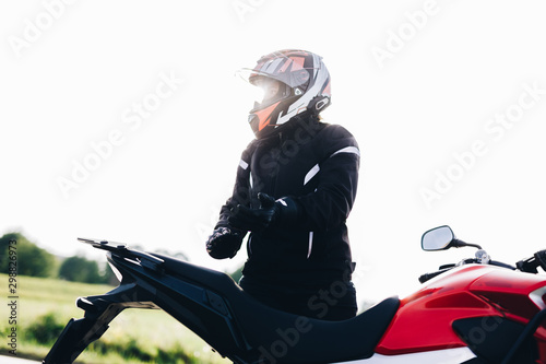 Woman preparing to drive a motorbike. Wearing gloves