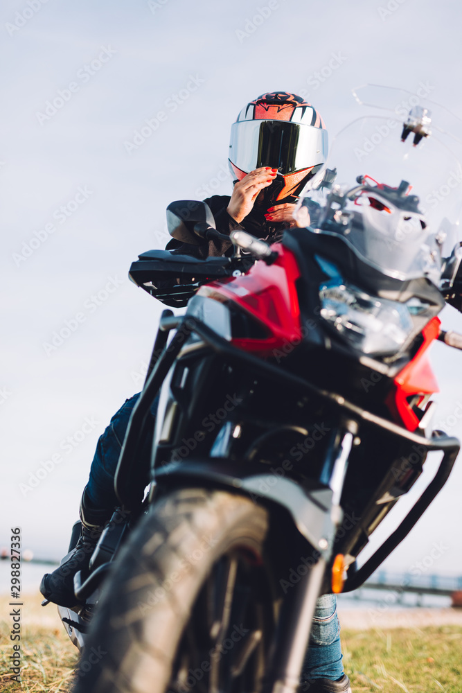 Woman on a motorbike looking at the ocean view. Adventure trip Woman on a motorbike looking at the ocean view. Adventure trip