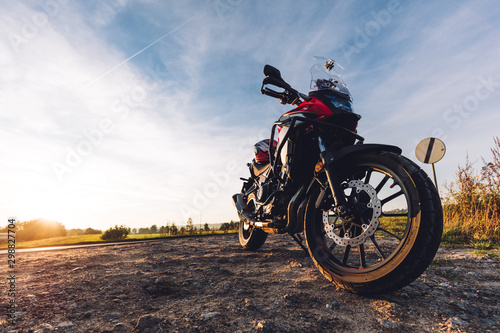 Fototapeta Naklejka Na Ścianę i Meble -  Adventure motorbike on roadside at sunset. Offroad trip.