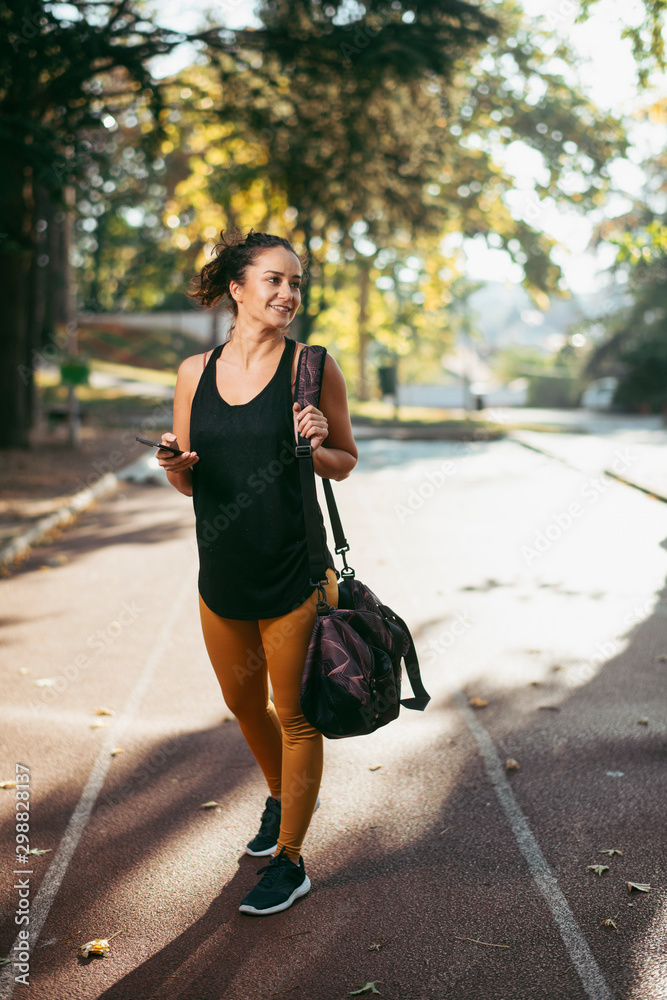 Portrait of young sporty woman using phone outdoors. Beautiful woman in sportswear. Portrait of young sporty woman using phone outdoors. Beautiful woman in sportswear.