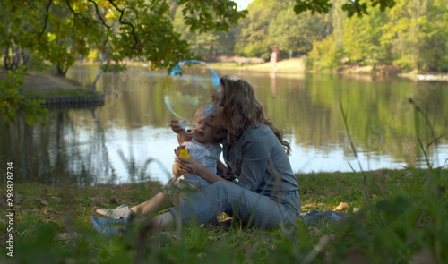 Happy mother and her son blowing soap bubbles