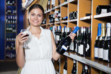 girl in white dress trying red wine at a wine store