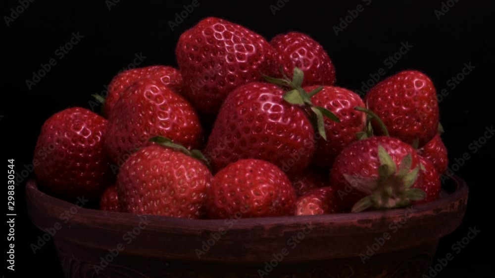 Rotation of juicy ripe strawberries in ceramic dishes on black background. Rotation 360 degrees, closeup. 4K - 50fps Rotation of juicy ripe strawberries in ceramic dishes on black background. Rotation 360 degrees, closeup. 4K - 50fps