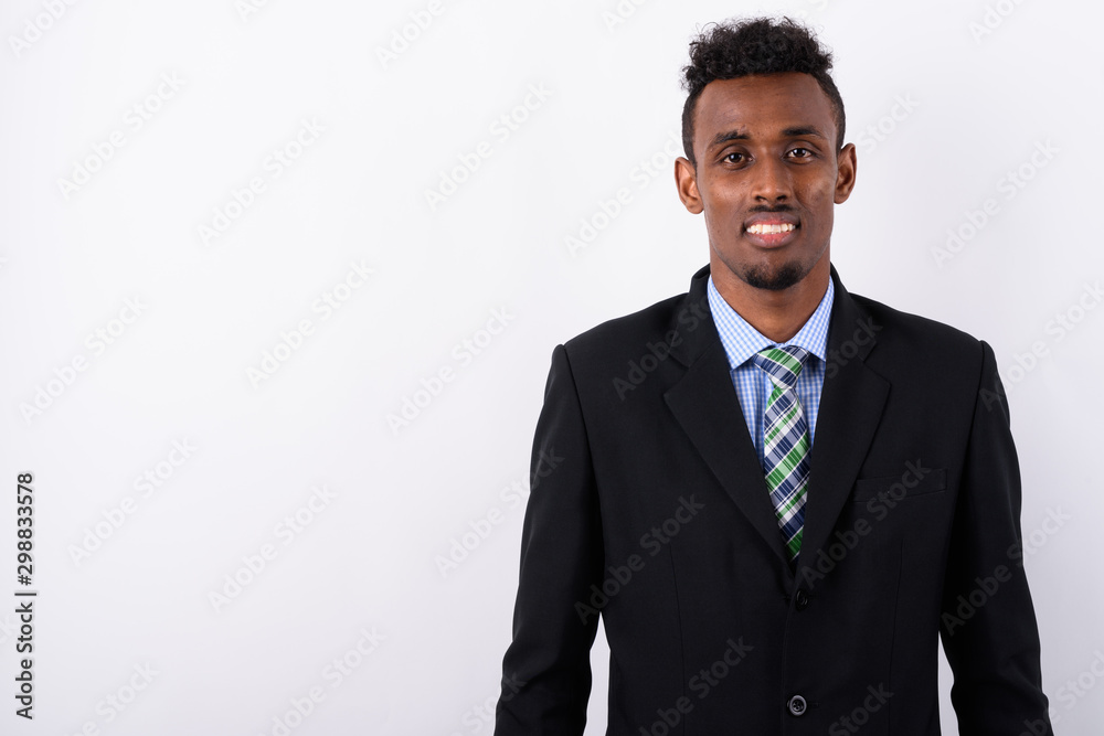 Young bearded African businessman wearing suit against white bac Young bearded African businessman wearing suit against white bac