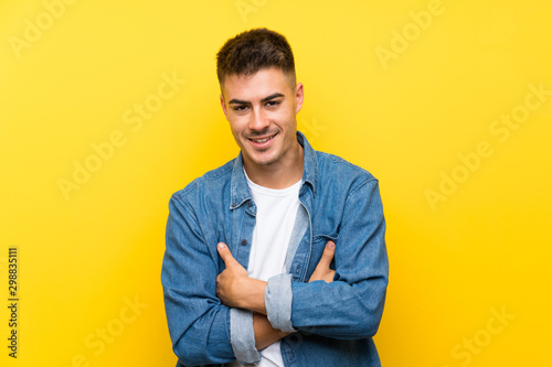 Young handsome man over isolated yellow background laughing © luismolinero