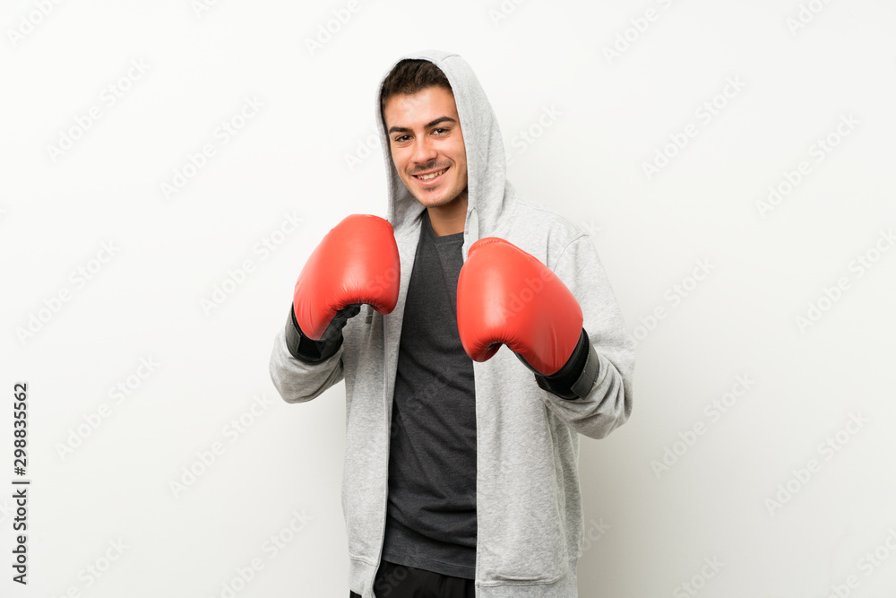 Sport man over isolated white wall with boxing gloves Sport man over isolated white wall with boxing gloves