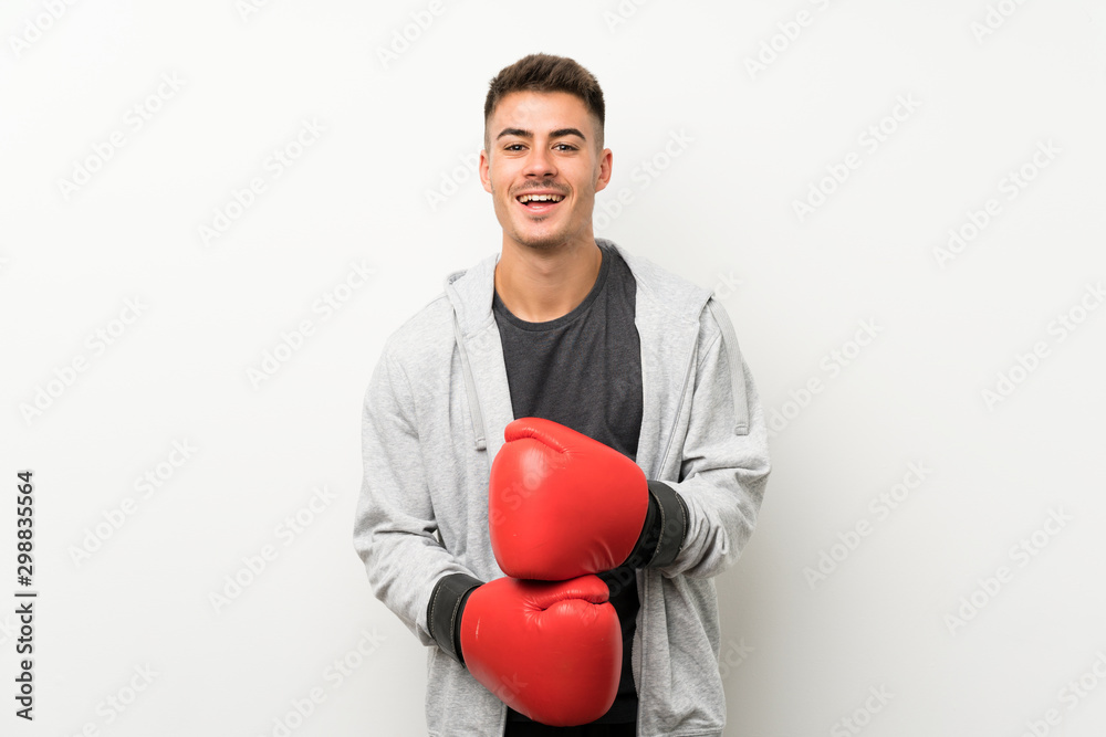 Sport man over isolated white wall with boxing gloves Sport man over isolated white wall with boxing gloves