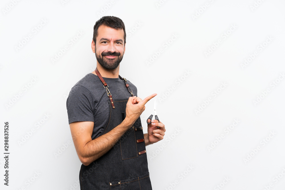Barber man in an apron pointing to the side to present a product Barber man in an apron pointing to the side to present a product