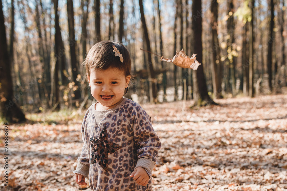 adorable baby girl in in an animal print sweater and yellow leggings,  autumn forest Stock Photo | Adobe Stock