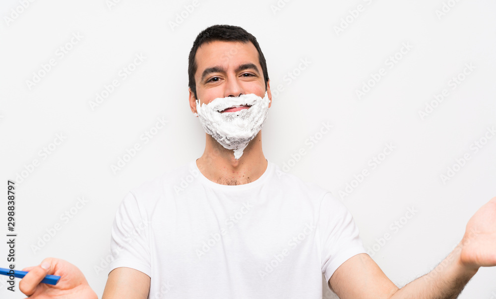 Man shaving his beard over isolated white background presenting and inviting to come with hand