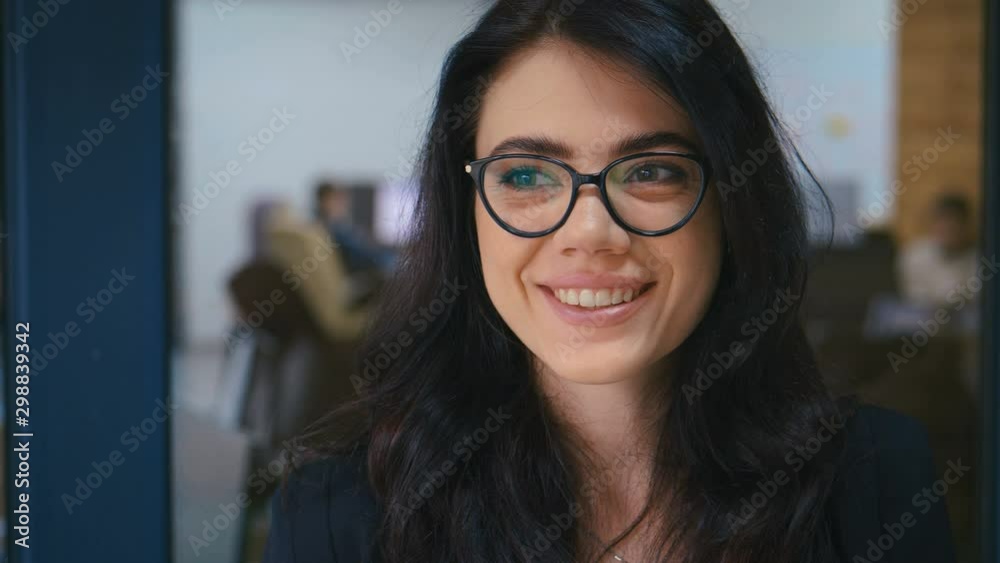 Attractive Young Businesswoman in Glasses Working on a Laptop in Modern Office Attractive Young Businesswoman in Glasses Working on a Laptop in Modern Office