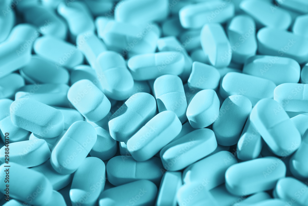 Blue monochrome Background of pile of tablets on the table. Healthcare and medicine concept drugs safety consumption or misuse with copy space Blue monochrome Background of pile of tablets on the table. Healthcare and medicine concept drugs safety consumption or misuse with copy space