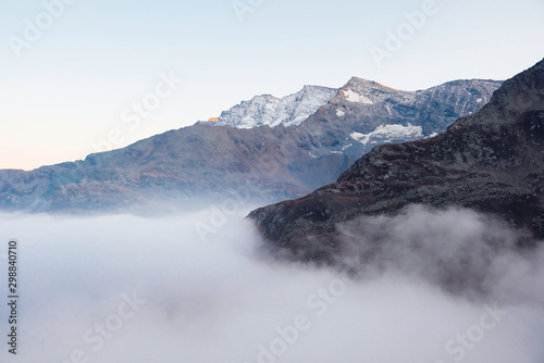 Snow covered mountain peaks in the clouds.