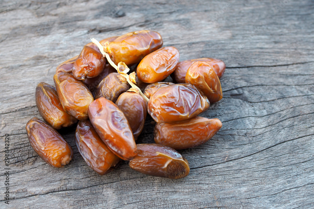 Close up fruits of date palm on old wooden background Close up fruits of date palm on old wooden background