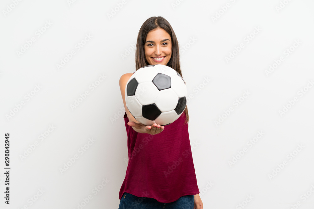 Young woman over isolated white background holding a soccer ball