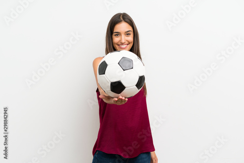 Young woman over isolated white background holding a soccer ball © luismolinero
