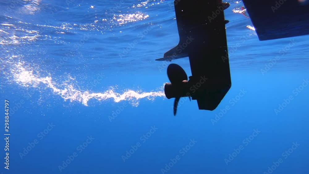 Underwater shot of boat propeller engine spinning.