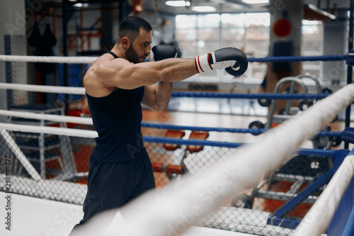 young ambitious sportsman warming up before boxing with his opponent. close up side view photo. free time, spare time