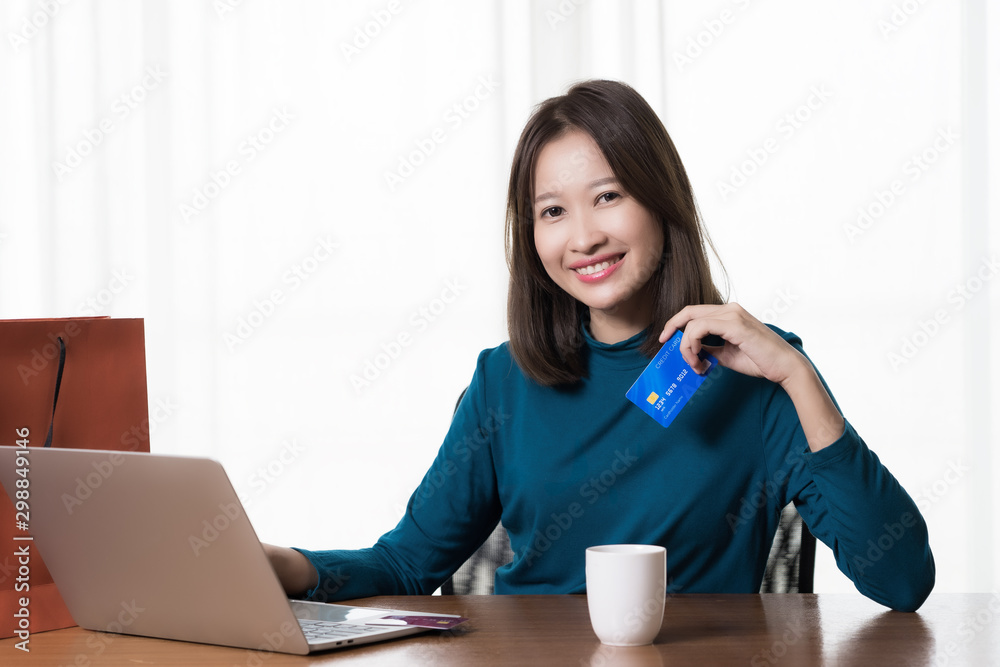 Happy Asian woman shopping online and paying by credit card.technology and ecommerce concept Happy Asian woman shopping online and paying by credit card.technology and ecommerce concept