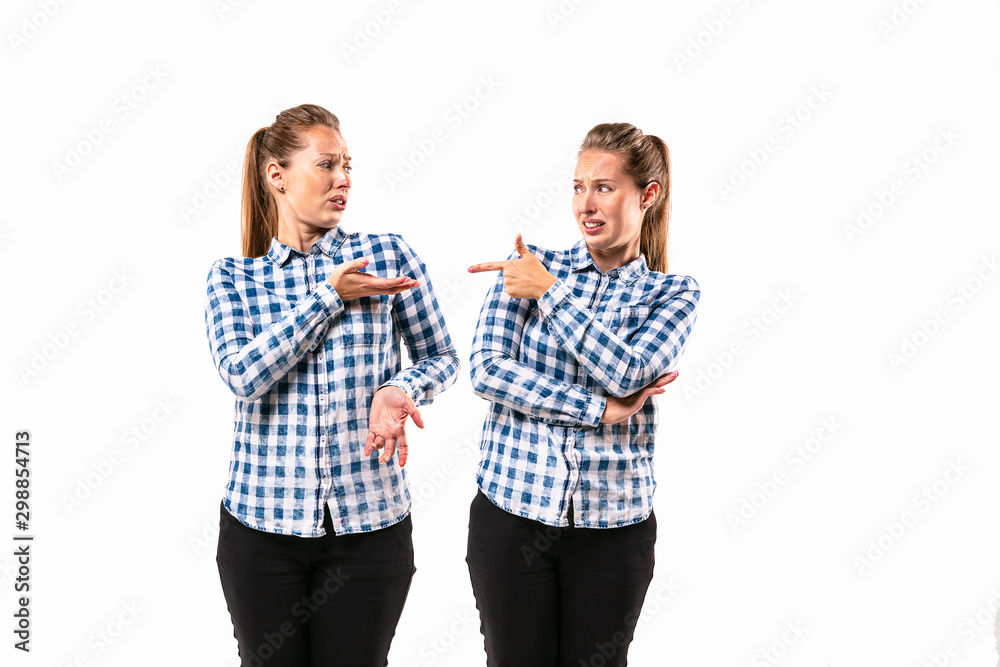 Young handsome woman arguing with herself on white studio background. Concept of human emotions, expression, mental issues, internal conflict, split personality. Half-length portrait. Negative space. Young handsome woman arguing with herself on white studio background. Concept of human emotions, expression, mental issues, internal conflict, split personality. Half-length portrait. Negative space.