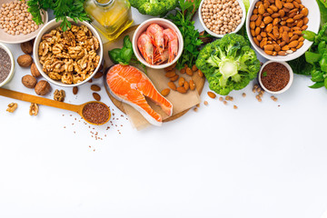 Food sources of omega 3 and omega 6 on white background top view. Foods high in fatty acids including vegetables, seafood, nut and seeds