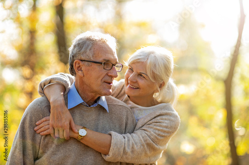 Elderly couple embracing in autumn park 