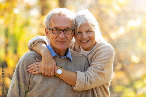 Elderly couple embracing in autumn park  photo