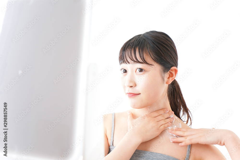 肌にクリームを塗る若い女性
