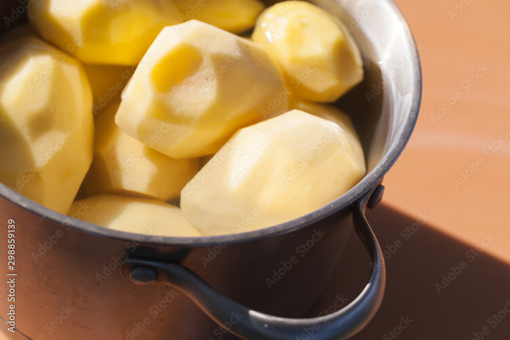 Raw peeled potatoes in a pan Raw peeled potatoes in a pan