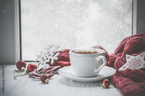 Winter cozy hot chocolate in front of window, snow, sweater. Lazy weekend, love, comfort