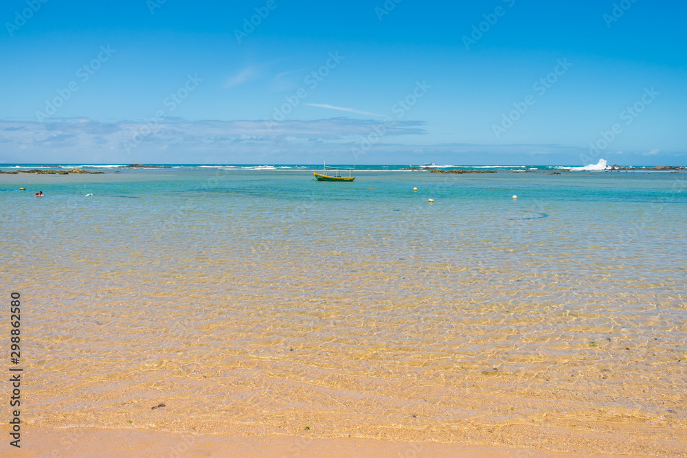 Salvador, Brazil - Circa September 2019: A view of Farol de Itapua beach - boat, calm waters and beautiful turquoise sea