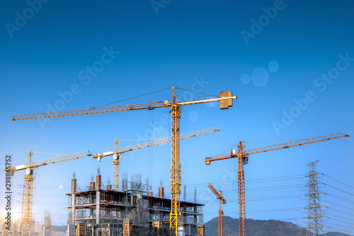 Workers are working on large construction sites and many cranes are working in the construction industry.
