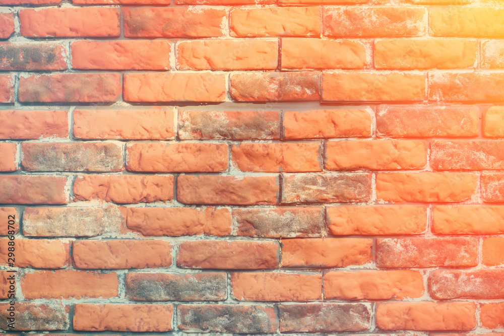 Retro background wasting away of the brickwork, close-up. Texture brick wall is red with grey color. Background of old worn brick wall, sun rays. Retro background wasting away of the brickwork, close-up. Texture brick wall is red with grey color. Background of old worn brick wall, sun rays.
