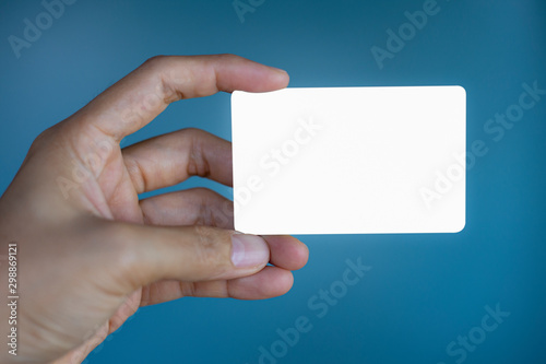 Hand holding a blank piece of paper. Close up white business card.