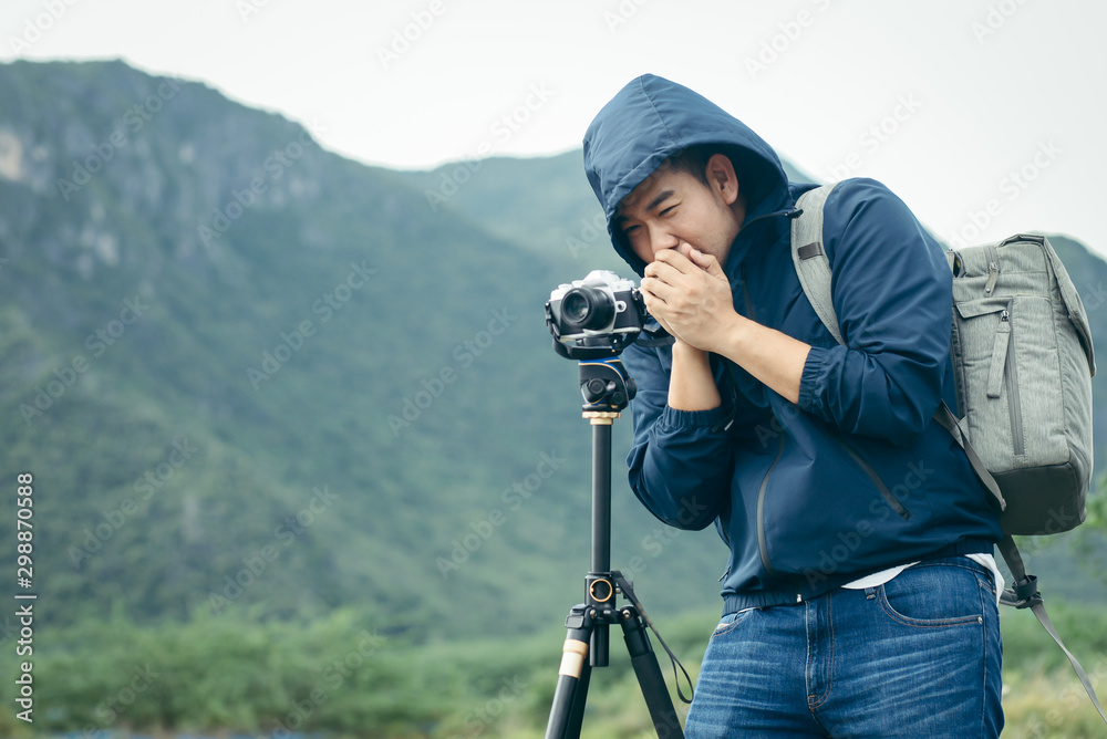 Asian photographer taking photo with tripod in winter season, lifetyle concept.
