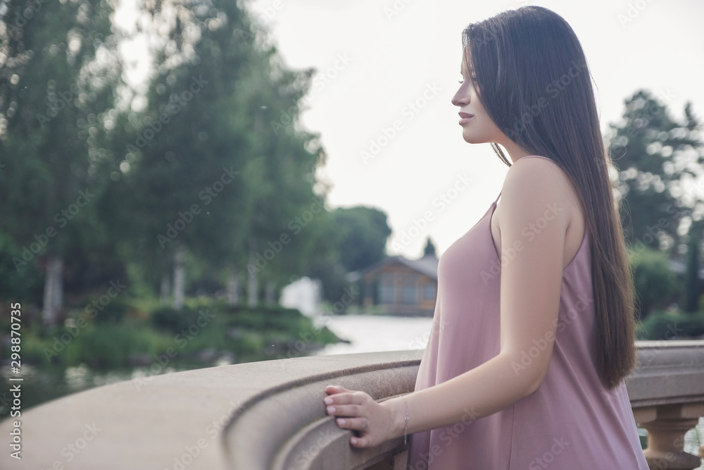Sexy brunette pregnant woman in park. Summer day, sunset Sexy brunette pregnant woman in park. Summer day, sunset