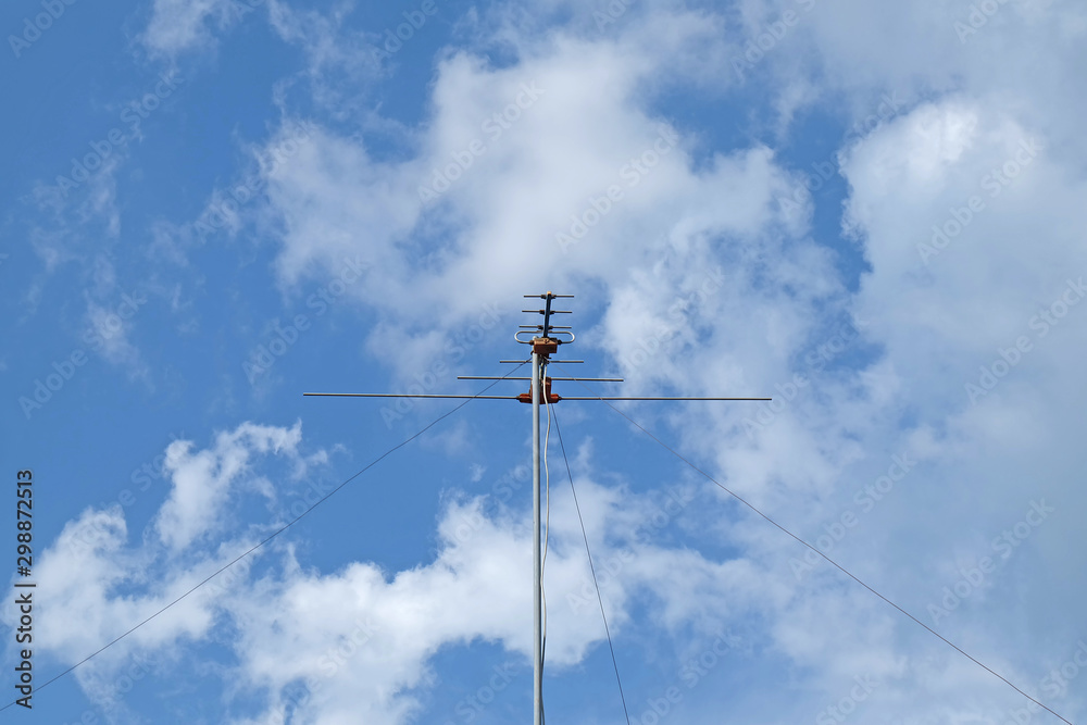 Old television signal receiver. Old ways to receive the body signal. A lot of antennas. TV antenna on blue sky background. Old television signal receiver. Old ways to receive the body signal. A lot of antennas. TV antenna on blue sky background.