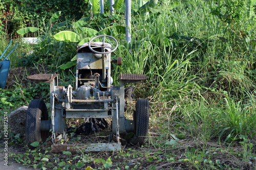 Wasted dilapidated rustic old farm tractor left on the vicinity of agricultural college campus