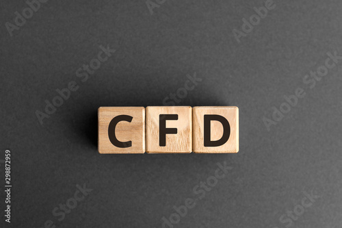 CFD - acronym from wooden blocks with letters, Contract For Difference CFD investment concept,  top view on grey background photo