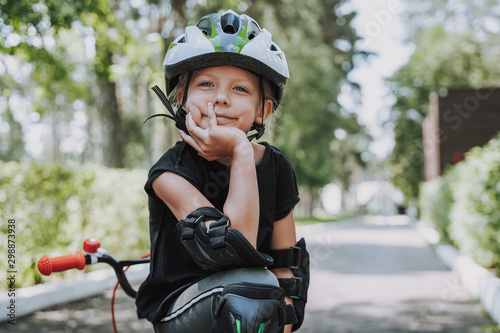 Cute little girl in bicycle helmet spending time outdoors