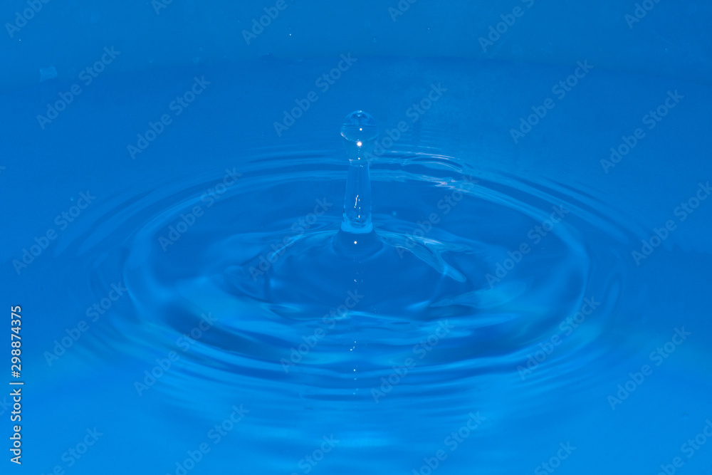 Water sculpture elongated in the middle of waves, created by a falling drop Water sculpture elongated in the middle of waves, created by a falling drop