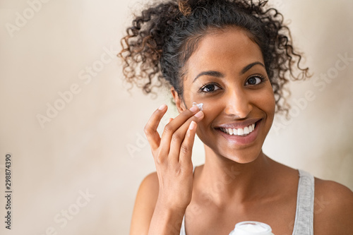 Beautiful girl applying face cream photo