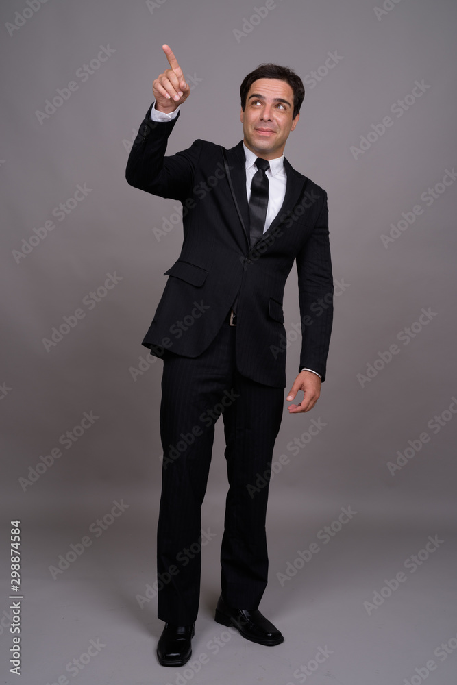 Full body shot of handsome Persian businessman in suit Full body shot of handsome Persian businessman in suit