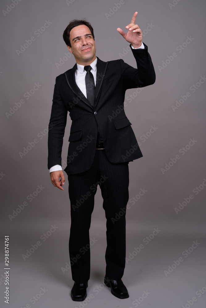Full body shot of handsome Persian businessman in suit Full body shot of handsome Persian businessman in suit
