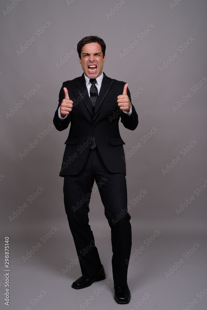 Full body shot of handsome Persian businessman in suit Full body shot of handsome Persian businessman in suit