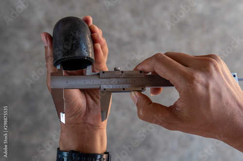Billede på lærred Using Vernier caliper to measure the dimensions inside diameter of the Elbow Pipe Fittings