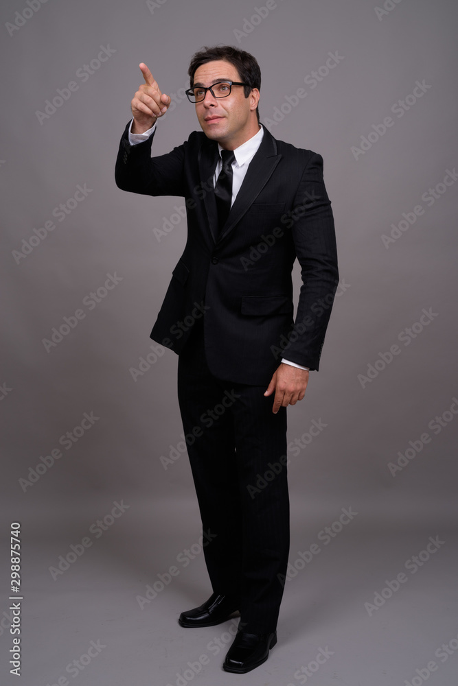 Full body shot of handsome Persian businessman in suit Full body shot of handsome Persian businessman in suit