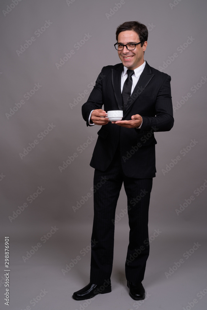 Full body shot of handsome Persian businessman in suit Full body shot of handsome Persian businessman in suit