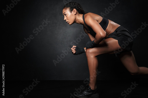 Image of african american woman in sportswear and hand wraps running